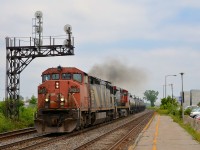 CN 377 passes a signal gantry at Dorval with CN 2423 and CN 2688 as power, both smoking it up as the train accelerates.