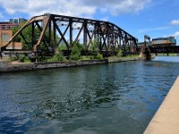 <b>At water level.</b> VIA 6428 backs up to Montreal's Central Station with an all-LRC consist as it crosses the Lachine canal. At left is the out of use CN swing bridge and behind it is the Wellington tower.