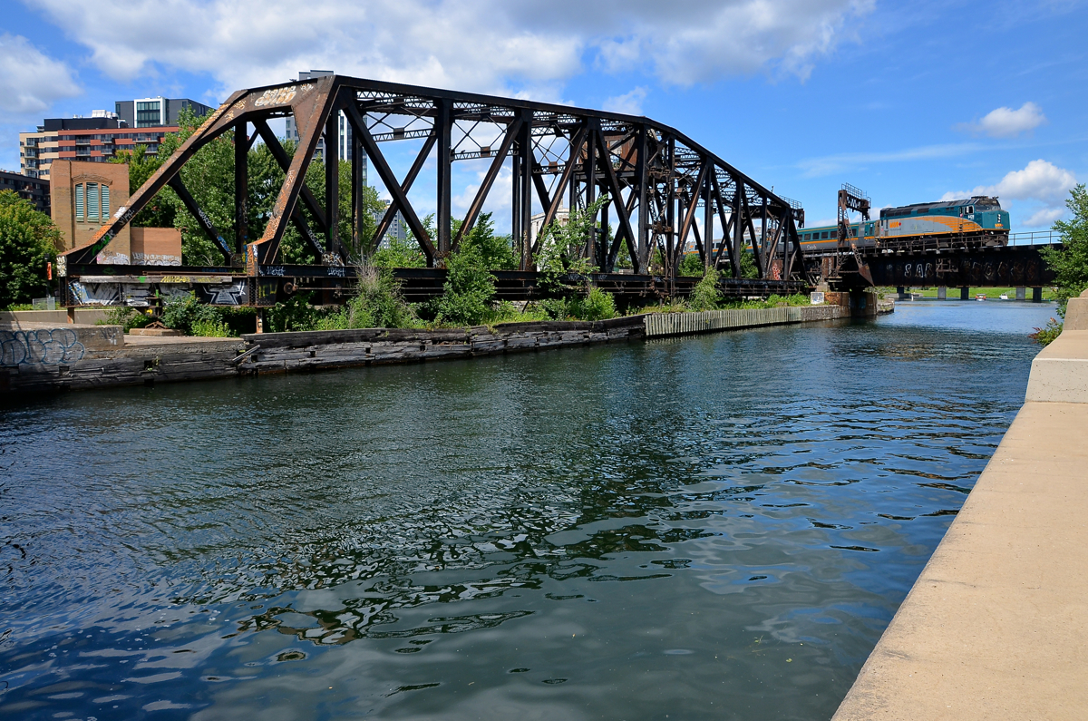 At water level. VIA 6428 backs up to Montreal's Central Station with an all-LRC consist as it crosses the Lachine canal. At left is the out of use CN swing bridge and behind it is the Wellington tower.