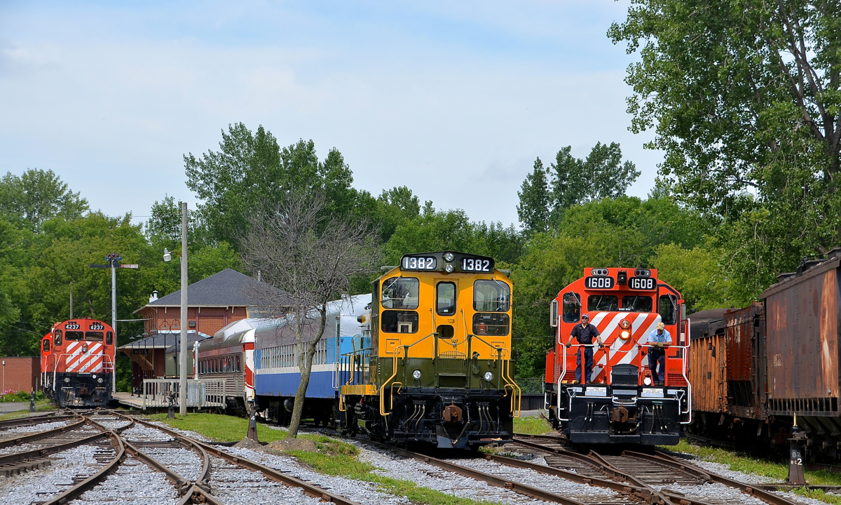 CP on either side of CN 1382. CN 1382 is in the middle of this photo, lashed up to AMT 827; this is the consist for the Sunday-only passenger train. At left in front of Barrington Station is CP 4237, with CP 4563 behind it. At right is CP 1608, on its way to the Des Bouleaux spur to do some tree trimming.
