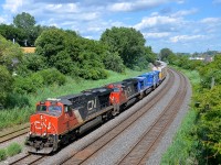 <b>Bluebirds in transit.</b> CN 401 has a pair of CEFX AC4400CW's in transit (CEFX 1016 & CEFX 1011) as it heads west through Montreal West. They are leaving the Arnaud Railway, with 1016 bound for the Providence & Worcester and 1011 heading to Canadian Allied Diesel. Ahead are two more GE products (CN 2257 & ex-ATSF CN 2199).