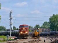 CP 550 is passing a Pettibone speedswing (CP 5510-33) in the Lasalle yard with CP 8797 leading and CP 8762 at the tail end. At right is a cut of tank cars, including a damaged one on a flat car (presumably going to CAD, which is nearby).