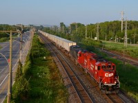 <b>On the south track for a change, with a GP20C-ECO leading.</b> CP 133 (the westbound Expressway, a dedicated piggyback train) normally operates on the north track of the Vaudreuil and Winchester sub. Today he was on the south track, allowing for a better view of the engines than normally at this location. An interesting lashup of two GP20C-ECO's and a CEFX AC4400CW (CP 2276, CP 2250 & CEFX 1058) leads CP 133 through Pointe-Claire on a sunny summer evening.