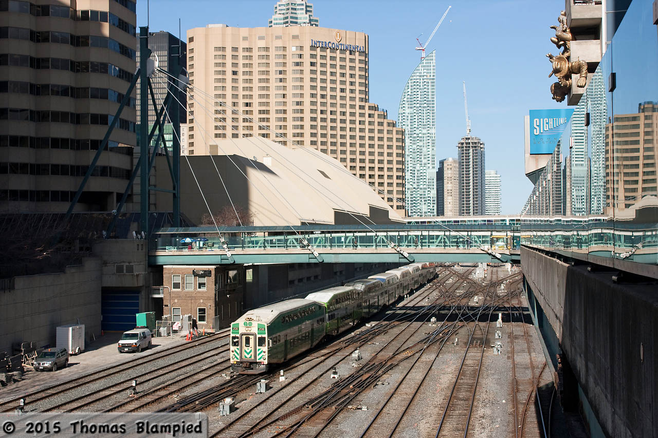 A slightly different take on the USRC. GO cab 208 navigates the trackwork as it passes the John Street tower (which lost its roof when the footbridge was built several decades ago). Meanwhile, in the top right corner of the frame, Toronto's most prominent trainspotter looks down from the sculpted figures on the side of the Rogers Centre/Skydome.