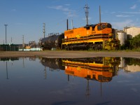 Thanks to rain fall the day previous, RLHH 3049 is seen casting a near perfect reflection as they spot a single tank car from one of Hamilton's many harbour-side industries.