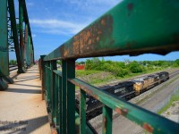 Central Ave bridge - a location, somewhat classic - many of the photos taken and shared from Fort Erie on railpictures.ca have been from, or showing this classic structure, such as <a href=http://www.railpictures.ca/?attachment_id=4081 target=_blank>John Eull's Amtrak Niagara Rainbow shot, 1975</a> or <a href=http://www.railpictures.ca/?attachment_id=15957 target=_blank>Arnold Mooney's</a> classic shots FROM the bridge, and lastly, Bill Thomson's <a href=http://www.railpictures.ca/?attachment_id=15124 target=_blank> New York Central E's under Central Ave, 1963</a> when the structure was not yet 10 years old. Built by the Bridge and Tank Company, Hamilton Bridge Division, Hamilton, Ontario, you can bet your stars the steel was made at Stelco or Dofasco, a connection that the Canadian industrial might the post 50's war boom could provide.<br><br>You'd think this is might be a eulogy, right? Well, it kinda is. This structure is about to come down, still in service, and I decided to spend some time documenting a bit more of the structure and incorporating it directly into a photo, and this is one of what I came up with, framed in the warped, rusting, and fading structure, likely to be replaced with something of far less charm, of contemporary design. For a structure built in 1952-1954 it sure seems much older. This bridge could last a few more months yet, maybe a year, tops. Also neat, the hydro wires that marred the shot a few months ago are now gone.<br><br>What about the train? NS H53 (on CN Rails - called CN M36931 by CN), the daily Buffalo to Fort Erie transfer, the last NS train operating into Ontario directly, is passing under Central Ave, only to sit at the border for a 2 to 3 hour wait before crossing. 