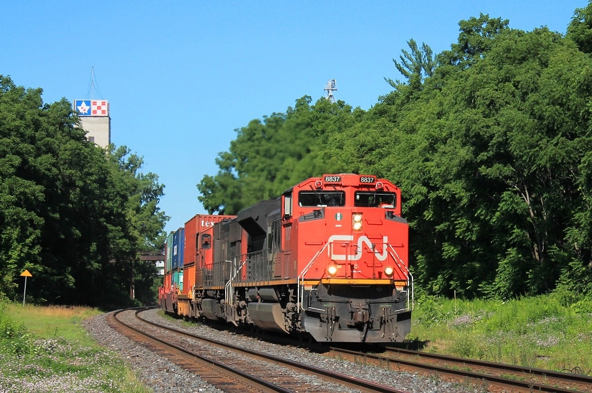 9:49 and 8837 and 5652 lead a long 148 Intermodal around the curve to the west of the station before powering up the bank.