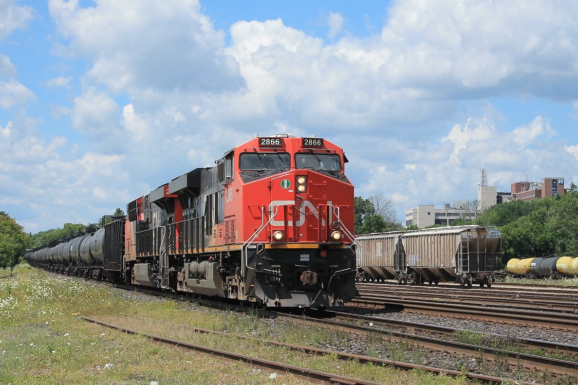 A long eastbound freight under the power of two AC's 2866 and 2896 on the southtrack. In the background is Brantford hospital that watches over the west end of the yard.