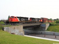 Canadian National intermodal train Q14891 with CN 5258 leading the way, a unique SD40-2W locomotive which was a former LNG test unit and a SD75I locomotive trailing as they speed past the New Westminster Drive underpass shot from Gilmore Park.