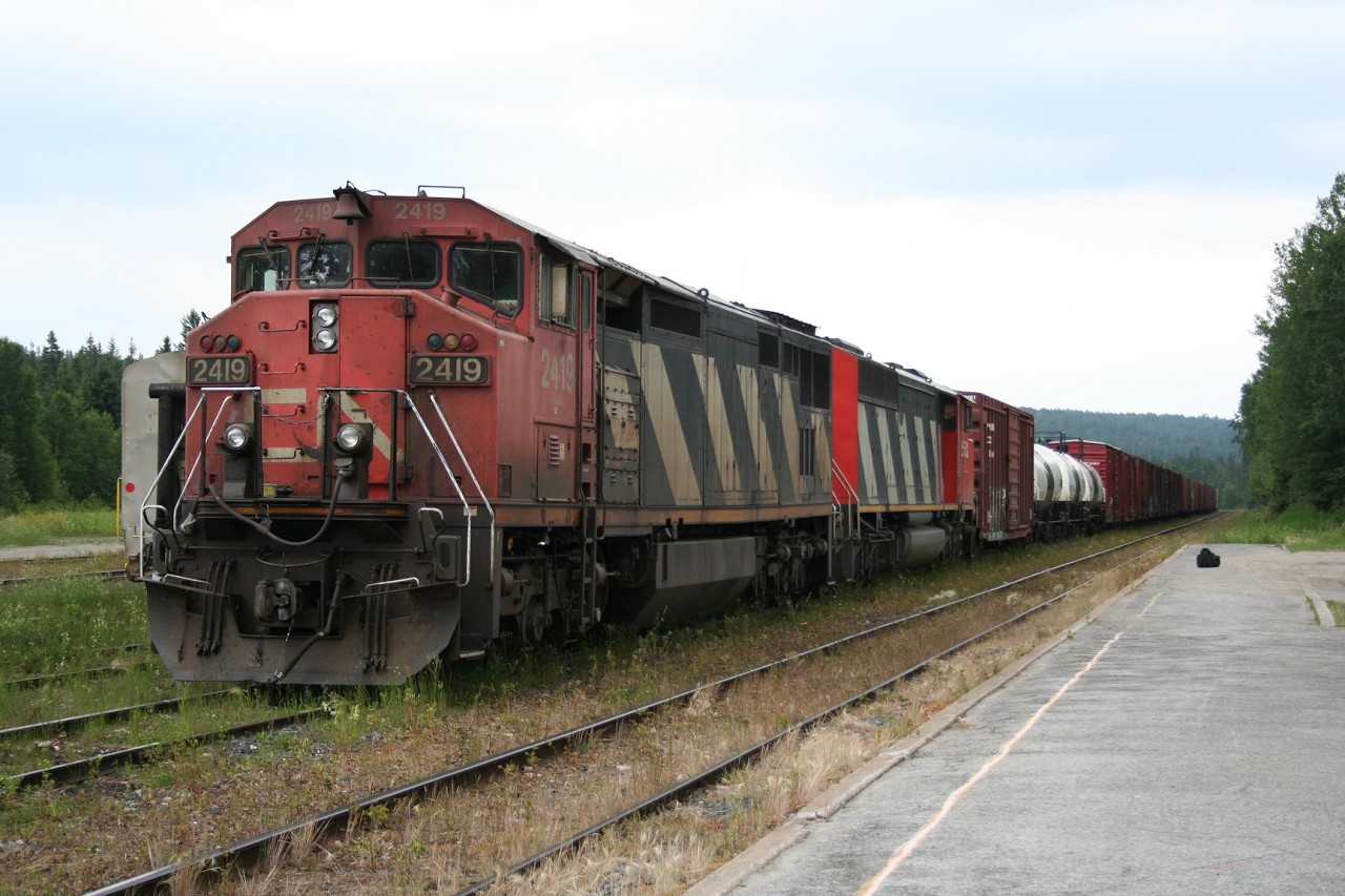 CN train 571 idles on a yard track at Hawk Junction as the passenger train will get the first turn to go north. Today's train is 28 cars of mostly interchange traffic for Canadian Pacific at Franz and empty pulpwood flatcars.