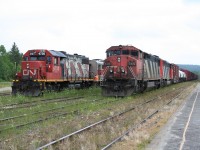 Side by side at Hawk Junction.

CN L571 with CN 2419 in the lead idles in the yard while beside it on another yard track CN 4730 prepares to move the regular passenger train from its overnight storage location over to the station platform.

Officially, the passenger train is a Sault Ste. Marie to Hearst schedule, however since new operator RailMark Canada took full control of the operation in late June, the schedule has been abysmally shattered.  Due to a gross lack of crew manpower, for the last several weeks of operation the train was operating north of Hawk Junction only, if it operated at all (an investigation into allegations of a major rules violation at one point shut down service for almost an entire week, stranding passengers and giving RailMark a huge black eye; the crew was apparently later cleared of wrongdoing, but could not operate a train during the investigation period). 

Sadly, the train seen here is actually the last northbound run of the passenger train out of Hawk Junction, as CN had put a stop to their relationship with RailMark effective July 15, 2015. And this train would only operate as far as Oba to runaround and return to Hawk Junction later that evening, with the equipment shipped off to Sault Ste. Marie the next day for storage.