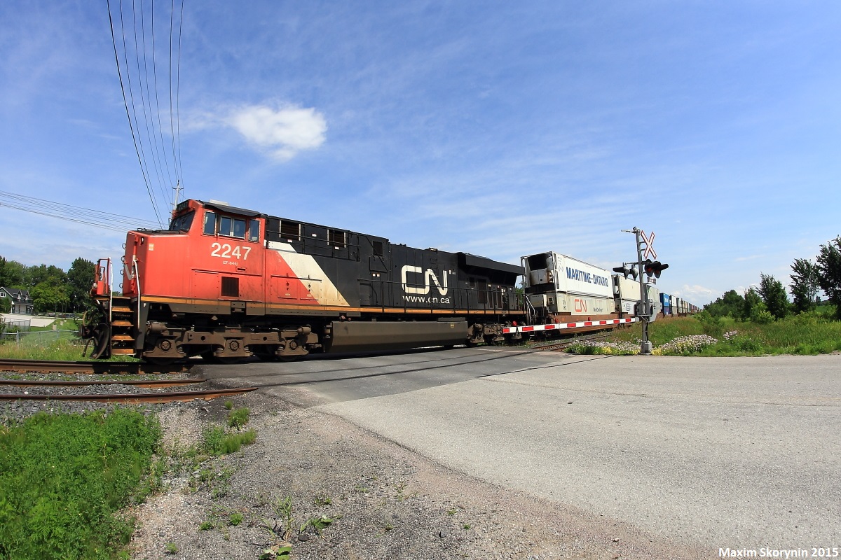 Intermodal train Q10721, a daily Montreal, Quebec to Winnipeg Manitoba train passes by the Ramara Rd grade crossing doing just under 40mp/h with only the ES44DC to handle the train. Q10721 had met its counterpart, Q10651, which runs from Robert's Bank, British Columbia to Montreal, Quebec at Quaker, a location about 40 miles south of where the photo was taken.