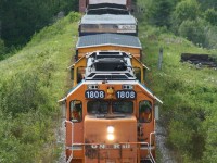 Ontario Northland train 515 (Kapuskasing to Cochrane) rolls across the Groundhog River bridge and through the tiny French-Canadian town of Fauquier with loads of paper from Kapuskasing, lumber from Kapuskasing, Hearst and Calstock, and copper concentrate from upper Michigan (via CN at Hearst).