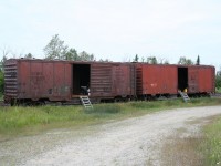 <p>An all but extinct species on most railroads, the venerable old forty foot boxcar can still occasionally be found in work service. Ontario Northland actually still operates a number of old boxcars in company service, so when visiting this railroad it's not too hard to see at least a few, even if at a distance.

<p>This pair of material storage cars were parked in the small yard at Porquis, the junction point where the lines to Timmins and Iroquois Falls diverge from the line up to Cochrane.