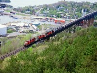  The sun is high overhead, but then, so am I, as I capture a nice shot of a southbound CP en route to MacTier for crew change, then onward to Toronto.  The view from the Fire Tower at the park is always worth checking out, but these days the forest of evergreens has reached the height that affects a clear shot of trains running south of the bridge. Also, directional running here now has most all trains operating as Northbounds on this CP and Southbound on the CN thru town. So, this shot now would be considered a rare catch. A long string of open autorack cars behind something like CP 5944, 5992 and 5547 is certainly a sighting of the past. Note to the left of the lead unit one can see the CN industrial trackage as well; which served the storage tanks. All of those are gone, as is the track. At 1,700 ft in length, the bridge over the Seguin River in town is a "must see" for those who have not yet been there.