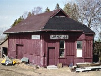 A decent early spring day on my day off work and once again I grabbed the little woman sidekick by the arm and hauled her off on another one of my wild goose chases. Looking for railroad stations I had heard were still in existence. Time was running short. These buildings in the mid to late '70s were coming down like dominos; having outlived their usefulness and becoming an annoyance for the railroads. This trip took us to check out Richmond Hill for the ONR-CN passenger at 0720, to Bradford, Barrie, Shanty Bay, the Orillia station and Trolley #4 as well as Gravenhurst and Washago. On the way back, we were to follow the roads to the east side of Lake Simcoe, specifically to check out "Elmer Jordan's farm, somewhere along old Ontario Hwy 46, location now I have forgotten, but somewhere near Woodville, call that just east of Cannington. This wasn't going to be easy, I thought. But, stopping at a general store in the area, I was told exactly how to get to Elmer's place; I guess he was well-known, and we made it there with little trouble. Now I wish I had made note of the directions. He was quite the friendly old guy (It helps to have a female with you) and sure enough, this little station was out back, hidden from view by a rickety old barn and a pile of typical barnyard junk. I loved it. Still had solid floors, the pot-bellied stove, and the whole bit. Apparently Elmer in his day used to work for the railroads, and when this station became expendable, he bought it and moved it to his farm. The building, a historical big deal to me, is the very last artifact out there from the early Toronto & Nipissing Rwy. It was at the junction of the Midland Rwy just north of Woodville; official name was Lorneville Junction station and it was a beehive of activity for people going from east/west and north/south here. Toronto to Coboconk or Beaverton to Lindsay. It has been 38 yrs as of this writing since I have seen this building. Now, as I write this caption,  I get to wondering what has become of it. Has it collapsed and died like so many farm outbuildings have over the past years? It is worthy now of a trip back, I should think.  Soon. It may already be too late.