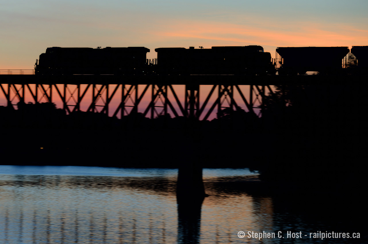 A peaceful silence is broken as the sound of growling GEVO's and steel girders resonate across the Speed River. CP train 255 is hustling through Galt, the engines growling as the hogger notches up to tackle the grade to Orrs lake. Below a few birds take flight, fearful of the noise from above, but we don't mind, do we :)

For the photographers - This photo is a combination of two techniques - a pan shot, AND a silhouette at the same time.  I haven't really had the opportunity to try this since (You need really low light!) and now it's your turn to judge. Let me know what you think :) What photographic challenge have you done (show us!). If you wish to see someone try something - what would that be?