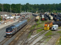 Can you spot all four trains? As you can see in this photo, the plant at "stuart" is fully in service, GO trains are in fact going in and out of here nearly daily (Training? Testing? Revenue service has yet to begin..) Metrolinx announced the start of service for Thursday July 9. For those who don't live here - the Greater Toronto area is preparing for the Pan-Am Games which start in the next couple weeks and this is partially why some of these massive projects are occurring now - Union Pearson Express, this station, and much more. In particular, the platform for the station behind me is still unfinished and the station only 40% complete at best, and yet, in 6 days, service starts.... I am actually looking forward to being able to take advantage of the platform once service begins - should open up a couple different angles here <br><br>
So back to the photo at hand - I count myself lucky - a side by side is hard to get - 3049 was busy switching cars in the yard, ducking in and out at right for the 30 minutes leading up to 97's arrival.  Will I get a side by side? Just before Amtrak was to come, the fuel truck pulls up beside 3049 and the crew took the break while the engine was refuling. Count my lucky stars.. I seem to have a few lately. :) <br><br>
So as I asked - where's Waldo? Or better yet, post in comment where the other trains are. :)



