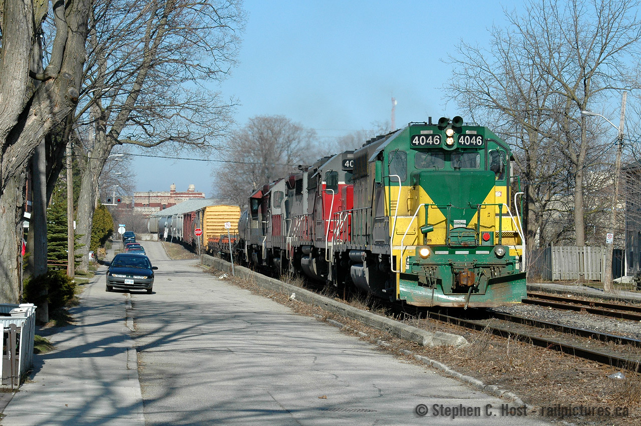 Ahh.. the start of my serious photography. Serious? Not really - but serious enough that I had purchased a Digital SLR a week or so prior - a Nikon D70 - at the time $3,000. I had shot film for about a year with my crappy 2 megapixel digital - the film was for my 'good' shots  - but the price of developing - and the pain in the butt of scanning and editing (which I had done this early in the game) made me quickly realize that a digital is cost effective by comparison. 
Even better, I lived just behind the house at right at 3 Glasgow St North, so I didn't have to go far to get this shot, This scene showing GEXR in its classic geep days - three, four, five, six... even as many as eight (!) four axle units could be found on 432/1 depending on tonnage and available engines. The four axle era ended approx 2006 when the purple/blue HLCX leasers arrived. 
The nickname for this engine, by local railfans at the time, was "John Deere". There were others.. who remembers "Barney" and "Tar Baby"??