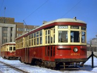 Toronto Transit Commission Peter Witt streetcars 2894 and 2834 sit at Ferry Loop off Queen's Quay, signed up as Bay and Dupont cars respectively, but both destined for the Docks (here). The TTC's Peter Witt fleet was running borrowed time, with only a few years left before the remaining cars were retired from regular service at the beginning of 1965. Ferry Loop, built in 1961 due to route changes associated with the Gardiner Expressway, would also stop being used in September 1965. In the background is the Government of Ontario Workmans Compensation Board building in background on Harbour Street (built 1953, later became the OPP Headquarters, demolished 2011). <br><br> Both cars were part of the 2800-2898 group of "small" Peter Witt cars (only even numbers) built by the Ottawa Car Company in the early 1920's. Car 2834 was likely scrapped sometime after retirement, but 2894 was sold off and sat in a barn on a property near Barrie, before the TTC acquired it back for overhaul and use on the Belt Line Tour Tram service in the 1970's. Today it resides at the Halton County Radial Railway Museum offering rides to visitors. <br><br> TTC 2834 and PCC car 4518, at Ferry Loop on the same day: <a href=http://www.railpictures.ca/?attachment_id=19019><b>http://www.railpictures.ca/?attachment_id=19019</b></a>