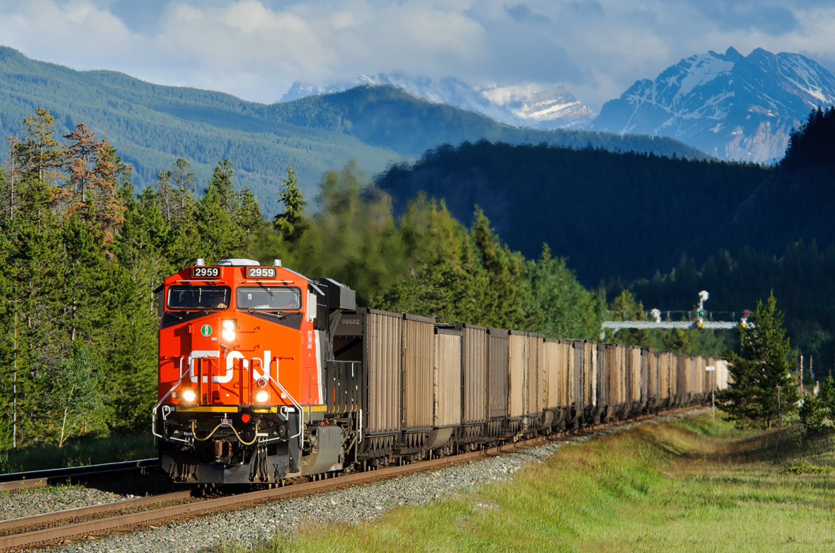 Still quite clean, CN ES44AC 2959 hustles empty coal buckets east on the Edson Sub.