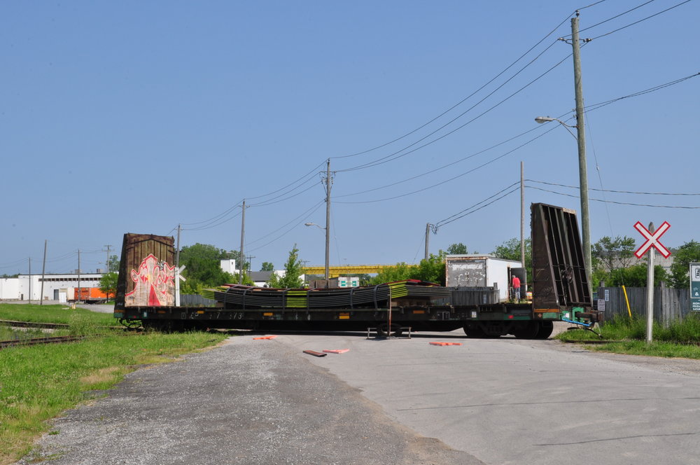 While crossing the diamond sometime Friday, the engine made it by fine, but the car it was hauling..did not. The city then blocked off the road until Saturday morning, when this was taken. It was still sitting here, and almost looks like one of the construction signs are tucked under the car. I have no clue when it was removed. Trillium 1859 is parked at one of the industries down the line. They must have had a long train going, because they even had box cars parked along the abandon section of Grantham Spur.