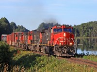 With only two of its four units on line CN 451 approaches the south siding switch at Martins, passing the calm waters of appropriately-named Siding Lake.