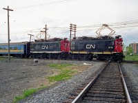 CN Z1a-class GE boxcab electric locomotives 6715 and 6710 (built 1916 and 1914 respectively) handle a commuter train with VIA-painted coaches, crossing the diamond with the CN St. Laurent Subdivision at Eastern Junction in May 1995. It was all but over for CN's vintage electric fleet still employed in Deux-Montagnes commuter service, as the remaining units retired a few months later when the final phase of renovations were completed on the line in Summer/Fall 1995.
<br><br>
Lead unit 6715 is preserved at the National Museum of Science and Technology in Ottawa, while 6710 can be found on display in front of AMT's Deux-Montagnes station.