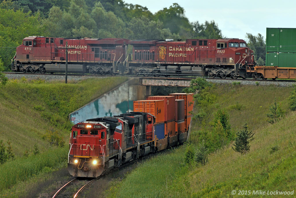 The classic over/under at Beare. It's pretty easy to do. First, open two shots in photoshop, one CP and one CN... heh. Ok, it's legit. CN 2100, 2544, and 5705 lead 149's train up the grade while CP 142's crew will be notching up 8712 and 8522 as their tail is now clear Staines. Back in the day, they'd already be rolling pretty good through here, but with 10,000' or greater trains on the Belleville Sub now, they're still watching the counter as they approach the crossing with CN. And CN? 10,000' is so 2001. 1439hrs.