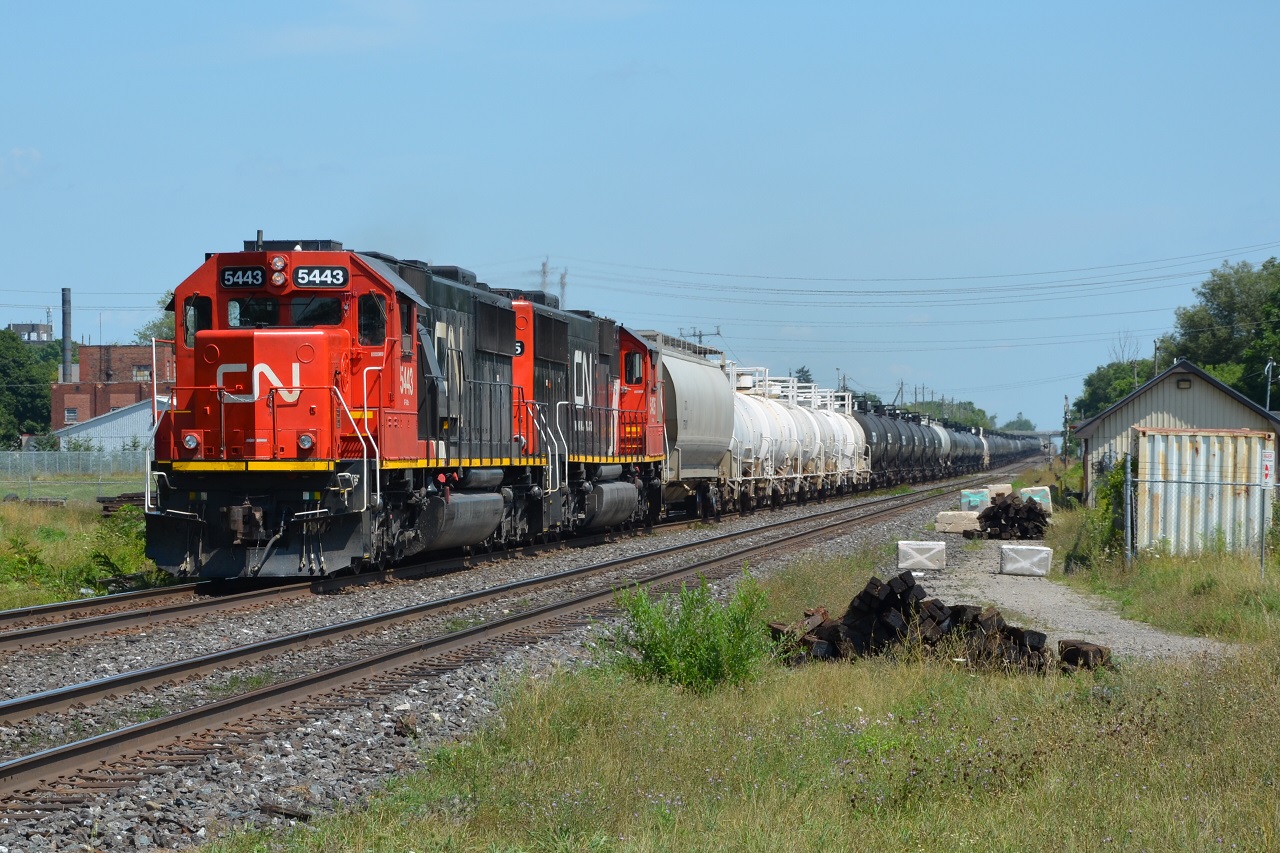 A pair of storage evading 60s lead 331 through Woodstock less than a minute behind VIA 73 which is sitting at the station on the south track about to depart.