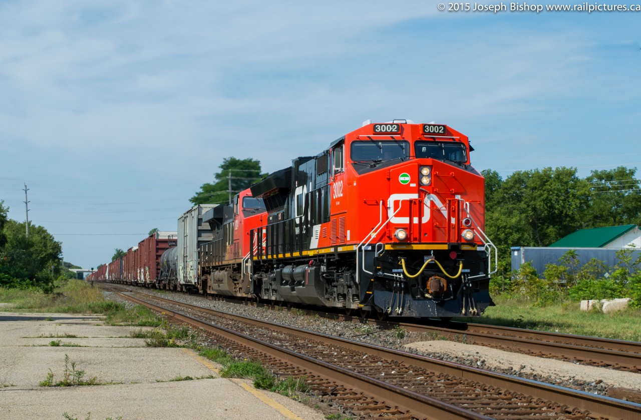 CN 3002, a GE ET44AC leads train 384 through Ingersoll Ontario on a sunny August morning.  3002 is one of the first tier 4 GEVO's to be delivered to CN and is just over a week old.