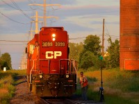 It's not too long before the sunset and CP 3099 has just left the spur from Total Canada and rejoined the Lasalle Loop, with the conductor about to climb back onto the engine after throwing the switch.