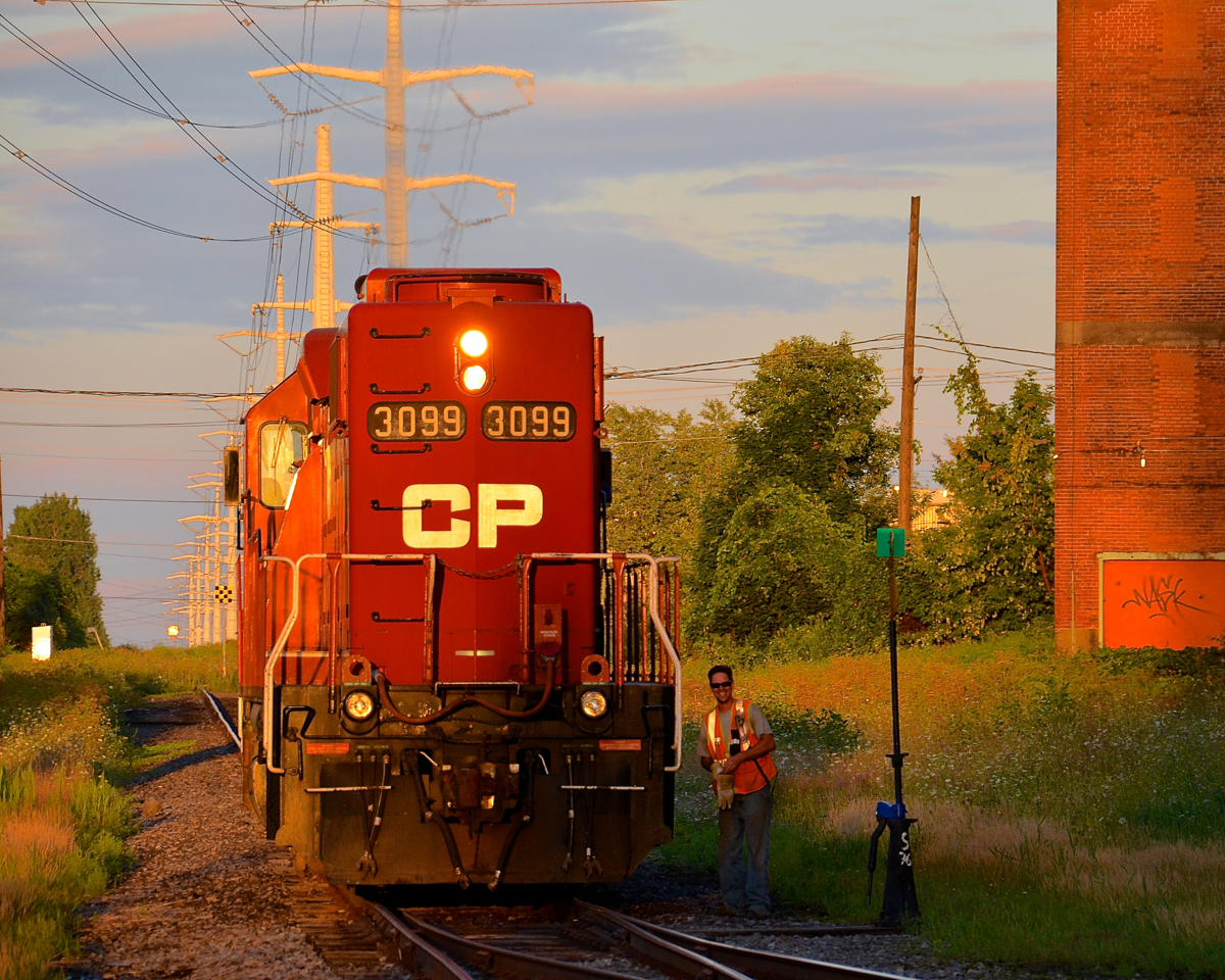 It's not too long before the sunset and CP 3099 has just left the spur from Total Canada and rejoined the Lasalle Loop, with the conductor about to climb back onto the engine after throwing the switch.