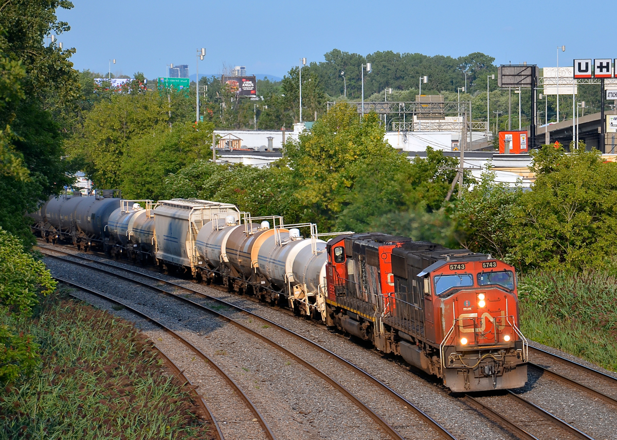 An SD75I and SD40-2W on CN 323. CN 323 is returning from Vermont with SD75I CN 5743 and SD40-2W CN 5281 as it rounds a curve in Montreal West.