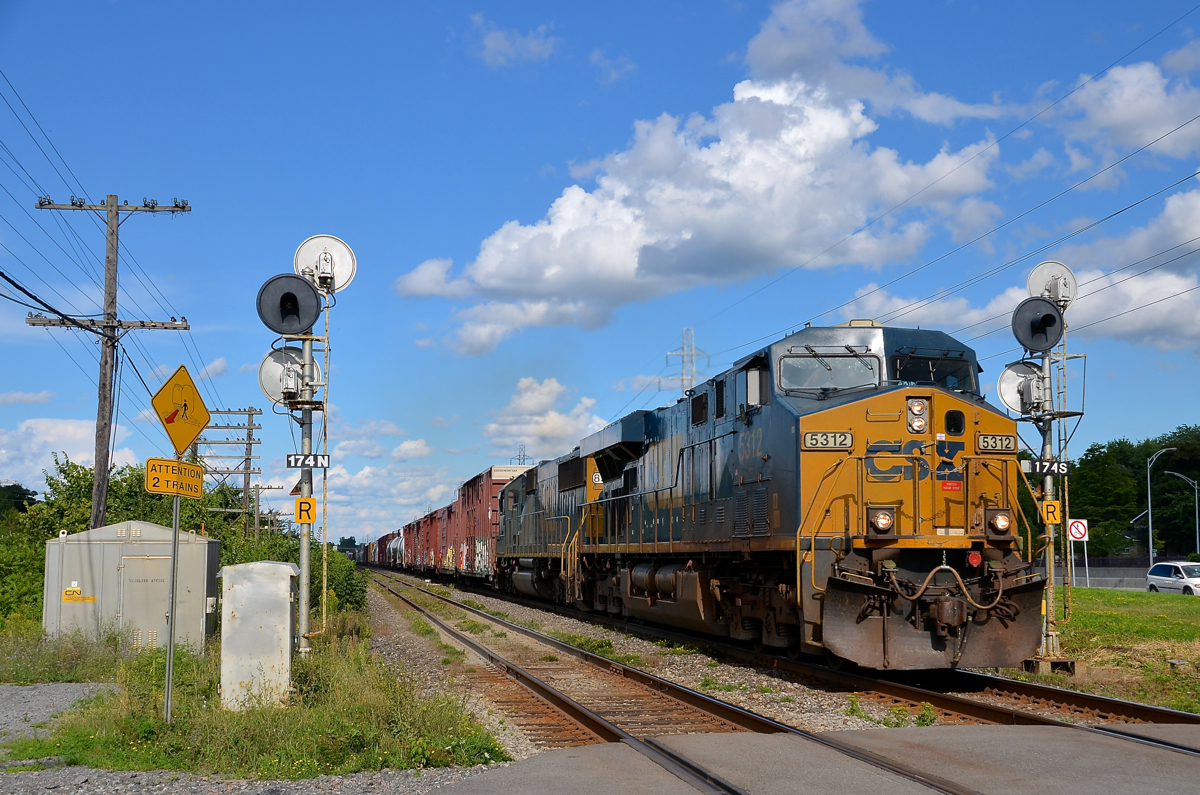 A CSXT ES40DC and SD50-2 (5312 & 8593) lead a later than usual CN 327 through Beaconsfield. They are about to cross over Woodland Avenue.