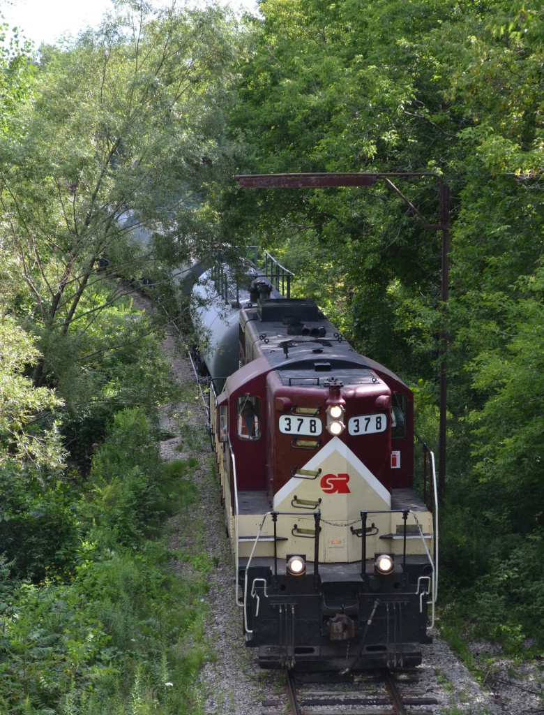 Ontario Southland train leaving Tillsonburg for Ingersoll behind GP-7 #378 approaching from the south. Photo taken from the now abandoned Canada Southern (CASO) bridge crossing both the former CN (now abandoned) and CP as well as a creek.
