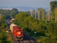 <b>The Dorion Turn through Pointe-Claire.</b> CP 2250 & CP 2256 lead the Dorion Turn westbound through Pointe-Claire. Behind it is Pointe-Claire Station and way in the distance is Mount-Royal