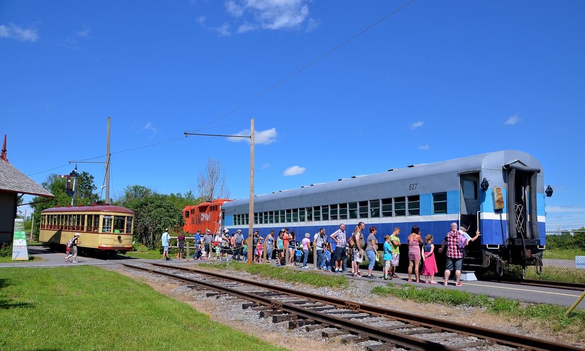 There's a decent sized lineup to get on the Sunday-only excursion train at Exporail, which consists of CP 1608 and ex-CP AMT 827 on this sunny afternoon. At left the streetcar is about to leave Barringston station.
