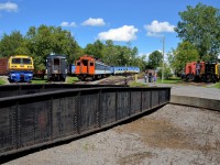 <b>Around the turntable.</b> A wide array of equipment is around Exporail's ex-CP turntable, including LRC -3 VIA 6921, two CN passenger cars, 70 tonner CN 30 and SW1200RSm CN 1382.