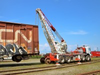 <b>Up in the air.</b> As part of the events for CN family day at Joffre yard, a CN crew demonstrates how to change out an axle on a boxcar.