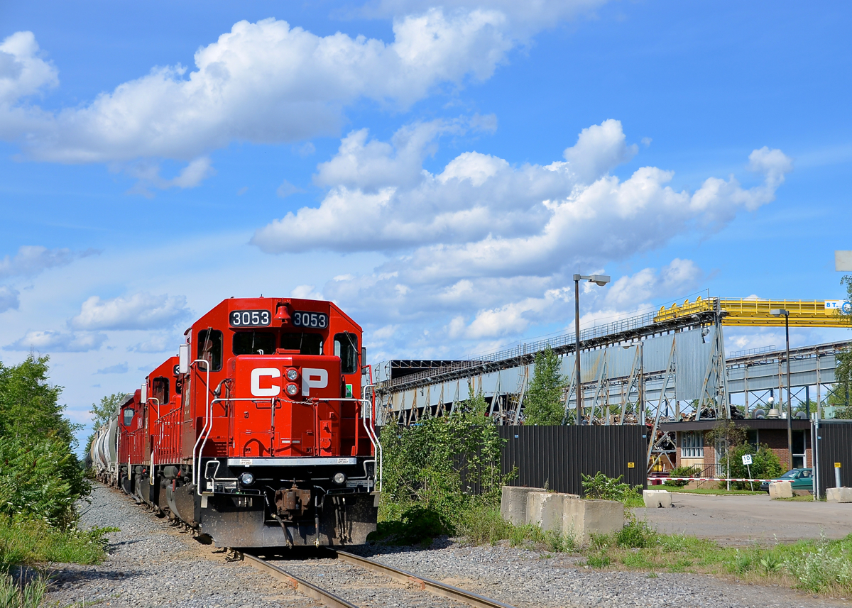 A CP switcher with three GP38-2's (CP 3053, CP 3204 & CP 3032) is stopped on the Seaway Spur, its crew just having taxied away, presumably they ran out of hours. At right is a junkyard in this very industrial section of the south shore, which has a number of customers served by CP.