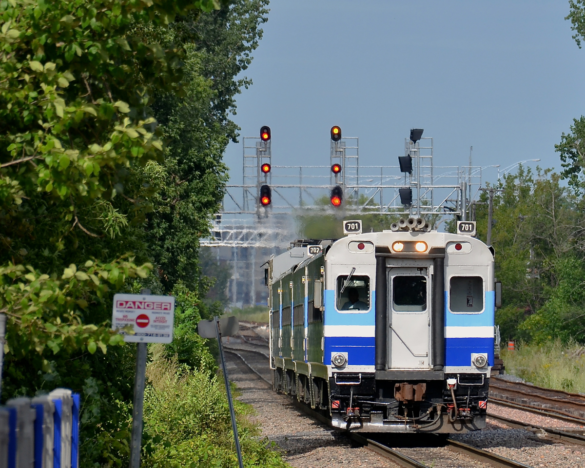 New signals. AMT 701 leads AMT 89 for Candiac towards its stop at Vendôme. In the distance are some new signals, the one at the right not yet cut in for a third track not yet in service.