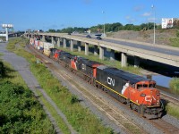 <b>GE variety and a repainted cowl leader.</b> CN 120 has a varied GE lashup, including Dash8-40CM CN 2434 leading, which was repainted in 2008. Trailing is ES44DC CN 2235, Dash9-44CW BCOL 4648 and ex-ATSF Dash8-40CW CN 2193. The train is passing through Turcot West in Montreal, ducking underneath the eastbound lanes of highway 20.