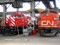 CN 9171 and CP 8921 sit next to each other inside the former Michigan Central locomotive shop, now the Elgin County Railway Museum.