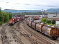<b><I>Time Machine.</b></I><br><br>When compared to <a href="http://www.railpictures.ca/?attachment_id=9110">sdforty's</a> image from 1986 the infrastructure may appear vastly unchanged, however don't be fooled. The "Shed Lead", once used as the track for the Canadian to pull through is used now mostly for "block swaps" (lifts and setoffs). The little spur off the Shed Lead still remains in the picture, although it is out of service as with most of the spurs which serviced all the businesses along Hardisty Street. <br>In this version, the East Wayfreight, train 434, Thunder Bay to Toronto pulls its small train out of E yard, sitting in pretty much the exact spot as the little switcher in sdforty's image. This wayfreight would be abolished within the year, with other mainline freights picking up the slack between the two points.<br>Another difference, the stone shop to the left of sdforty's image does not exist in this image. The building would be a victim of a fire at some point, I believe before the 1990's. A few more notes: the auto racks then and now are seen, there are no vans present at the shops anymore, instead replaced with SBU's (note the one laying beside the crossover switches) and as with many other places, the foliage has grown up!