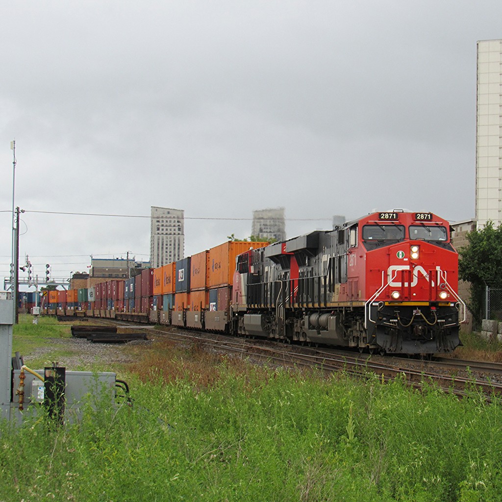 On a very rainy day in London, Ontario, CN 148 rolls down the track at CN McLeod on the Dundas Subdivision. Powered by a pair of shiny ES44AC's. All trains that were heading east or west past Komoka were put on the north track due to the heavy rain causing a problem at the approach to Komoka signals on the south track. Eventually, CN M330 would go into an emergency at Komoka, due to a signal on the north track too, being a stop signal, not a clear. Which was a malfunction due.