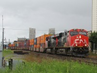 On a very rainy day in London, Ontario, CN 148 rolls down the track at CN McLeod on the Dundas Subdivision. Powered by a pair of shiny ES44AC's. All trains that were heading east or west past Komoka were put on the north track due to the heavy rain causing a problem at the approach to Komoka signals on the south track. Eventually, CN M330 would go into an emergency at Komoka, due to a signal on the north track too, being a stop signal, not a clear. Which was a malfunction due. 