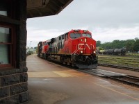 A morning of thunder showers and dark skies greet this eastbound mixed freight as it passes the stone façade of Brantford station. CN 2879 and 2910 apply the power.