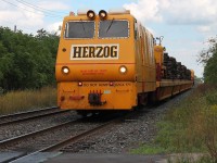 Herzog unit on the south track coming down Woodstock bank and crossing Norwich Avenue foot crossing. The train had a load of old wooden sleepers.