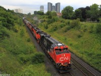 The daily Chambord to Toronto manifest is pulling into Toronto with a ES44AC leading Bessemer & Lake Erie EMD SD40-3T 910, and another 44AC helping out mid-train. The BLE 910, was purchased by Canadian National and was online and working on this train, as it ducked under the Hilda Avenue road bridge on its way to Toronto's MacMillan Yard. 